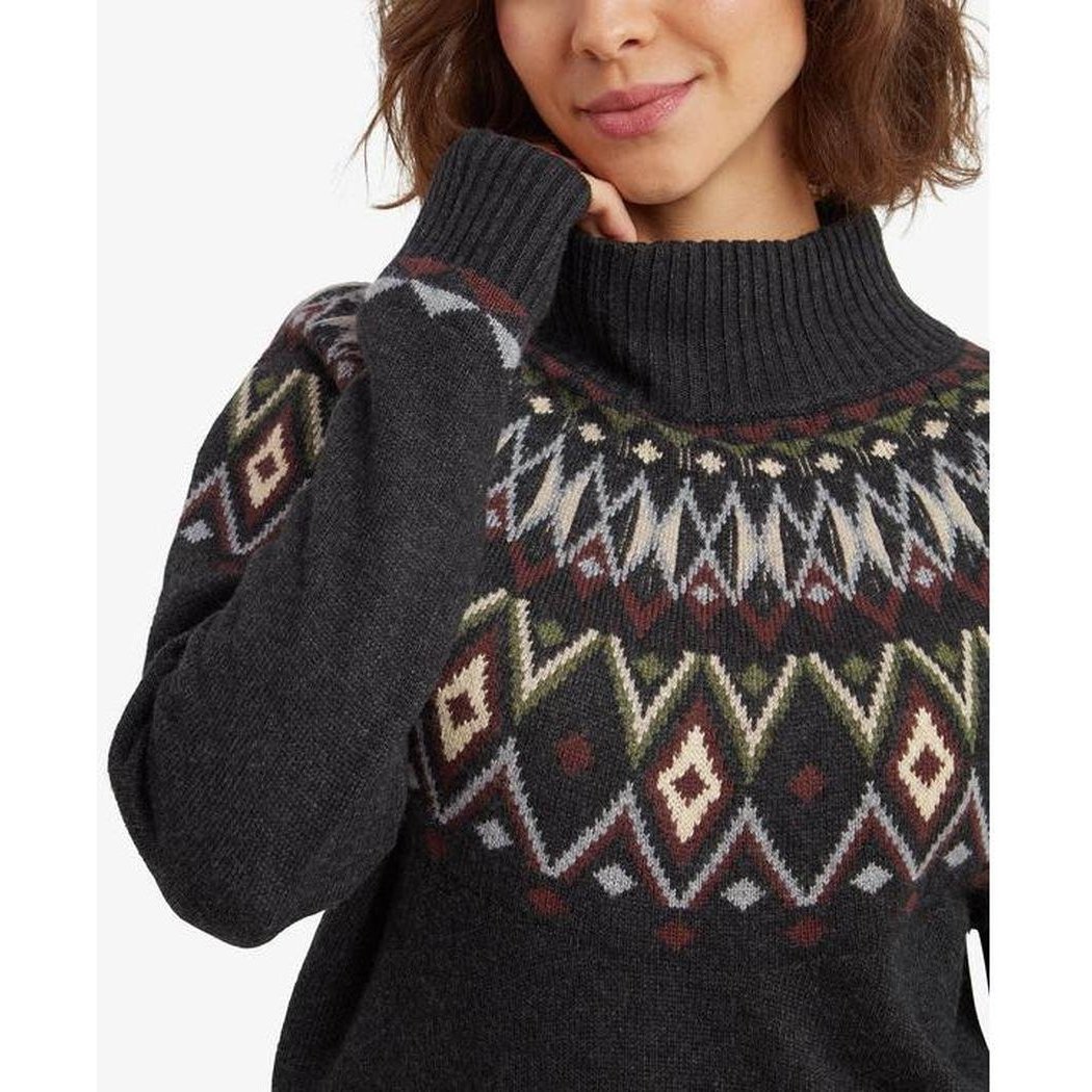 A woman wearing the Sherpa Adventure Gear Samples - Women's Indu Mock Neck in Black poses with one hand near her face against a plain white background.
