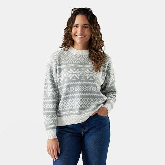 A woman wearing the Smartwool Women's Edgewood Heritage Crew Sweater in Light Gray stands against a plain white background.