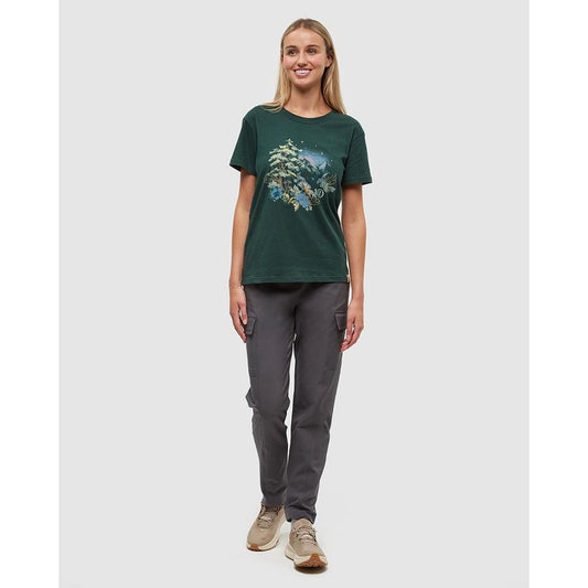 A woman wearing the Tentree Women's Regenerative Forest Sprawl T-Shirt in Forest Pine Granite Green stands against a plain white background.