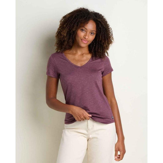 A woman wearing the Toad & Co Women's Marley II Short Sleeve Tee in Earth color stands against a plain light background.