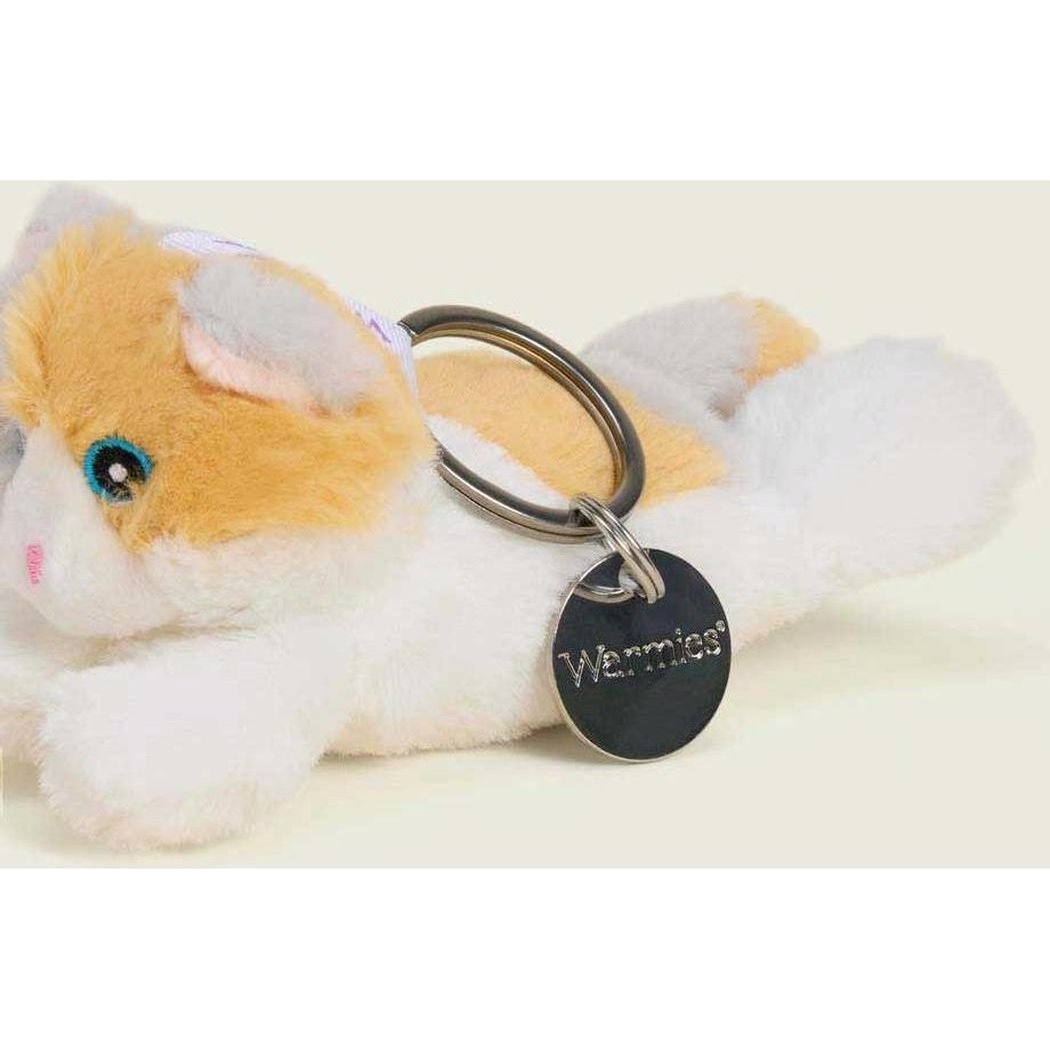 A close-up of the Warmies Calico Cat Keyring lying down with a black tag and metal ring visible against a light background.