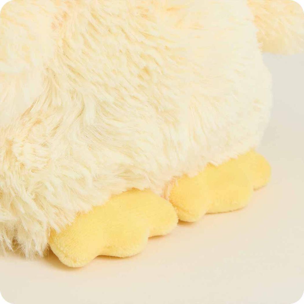 Close-up of the Warmies Chick Warmies Junior showing its yellow feet and fluffy cream body against a light background.