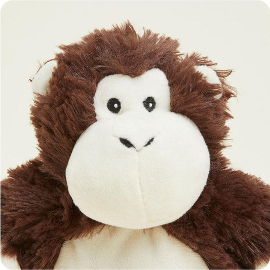 A close-up of the Warmies Monkey Junior plush toy with brown fur and a white face against a plain background.