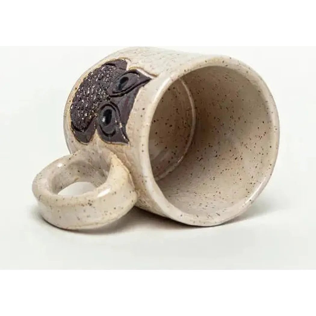 A side view of the White Squirrel Clayworks Classic Owl Design Handmade, in Ohio, Ceramic White 10oz Mug showing the owl design and ring handle against a white background.