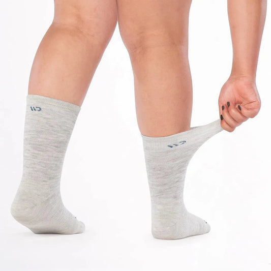 Side view of the Wide Open Women's Solid Basic Crew Lightweight No Cushion Socks in Ash showing the model wearing them against a white background.