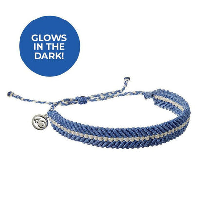 A close-up of the 4Ocean Deep Sea Beaded bracelet in Abyssal Blue Glow with a silver charm and a blue "GLOWS IN THE DARK!" circle above it.