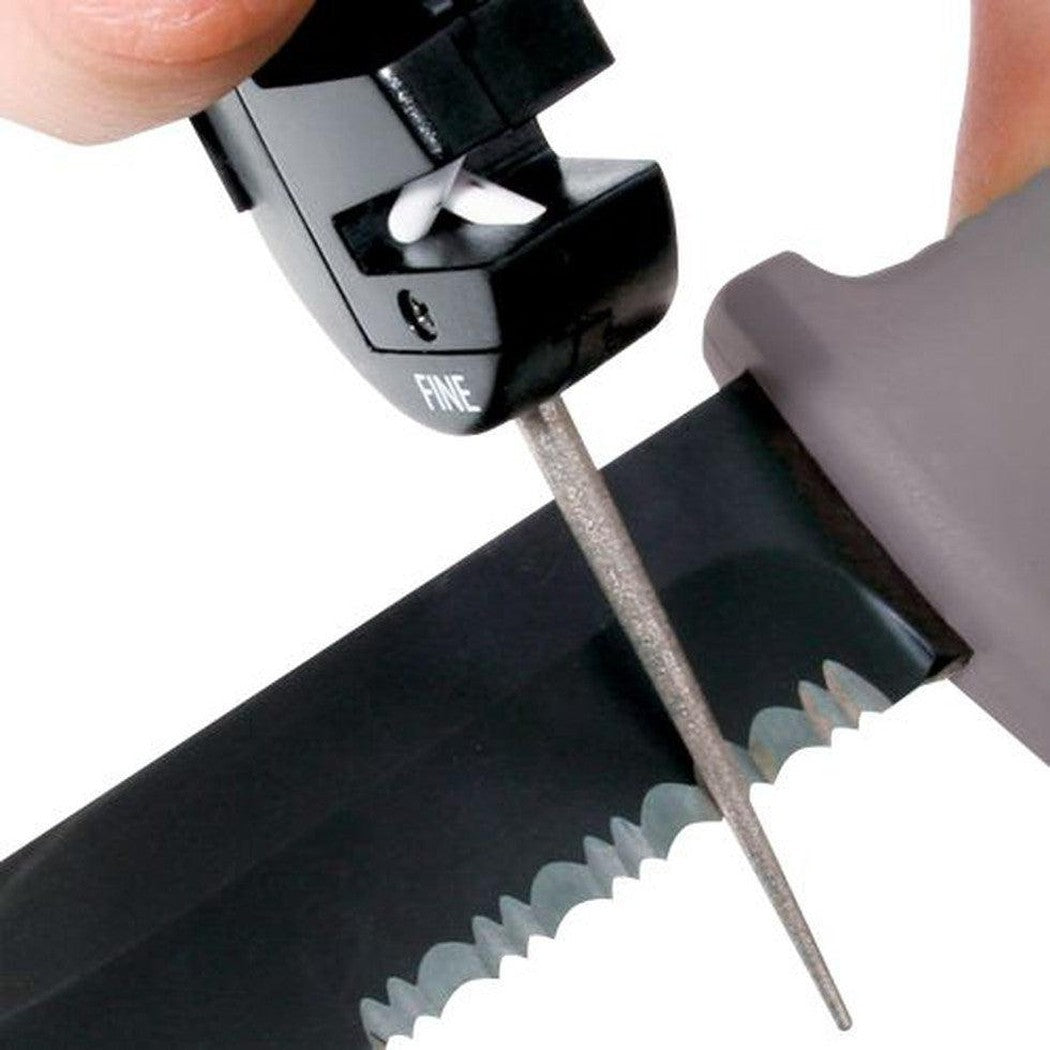A hand uses the AccuSharp 4-in-1 Knife & Tool Sharpener on a serrated knife blade against a white background.