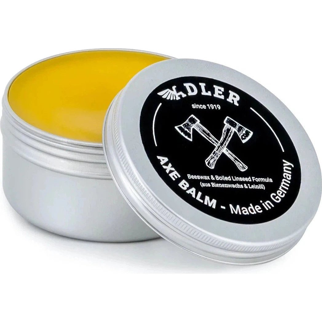 A silver tin of yellow Adler Axe Balm with a lid showing crossed axes and "Made in Germany" text, photographed from above.