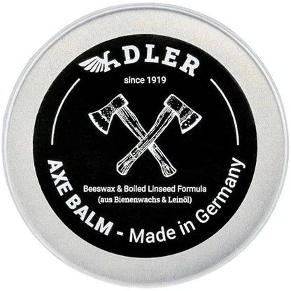 A round tin of Adler Axe Balm with crossed axes on the label, showing the product name and "Made in Germany" text.