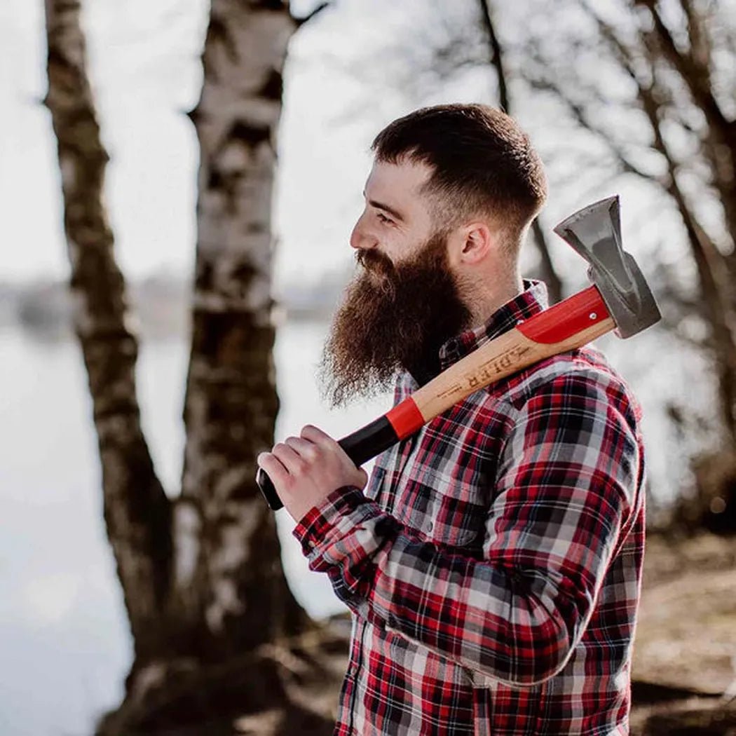A man in a plaid shirt holds the Adler Short Splitter over his shoulder by a lake with trees in the background.