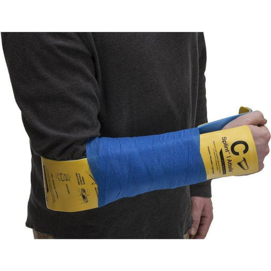 A person wearing a charcoal shirt has a blue Adventure Medical Kits C-Splint on their arm, showing the yellow packaging and the wrap.