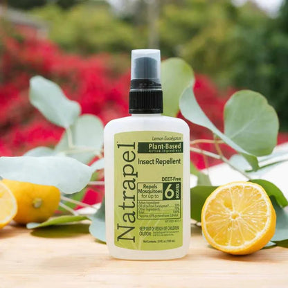 A close-up of the Natrapel Lemon Eucalyptus Pump bottle on a wooden surface with lemons and green leaves in the background.