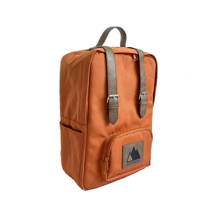 A front view of the Adventurist Backpack Co. Classic Backpack in Adobe color showing the front pocket and buckle straps against a white background.