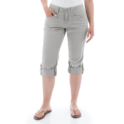 A woman wearing the Aventura Women's Arden V2 Capri in Quarry stands against a white background with rolled cuffs visible.