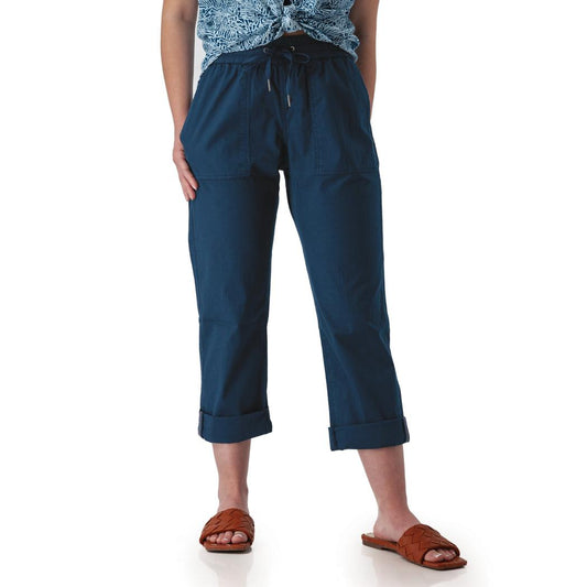 Side view of the Aventura Women's Ballard Ankle Pant in Botanical Green showing the drawstring waist and rolled cuffs on a model wearing brown sandals against a white background.