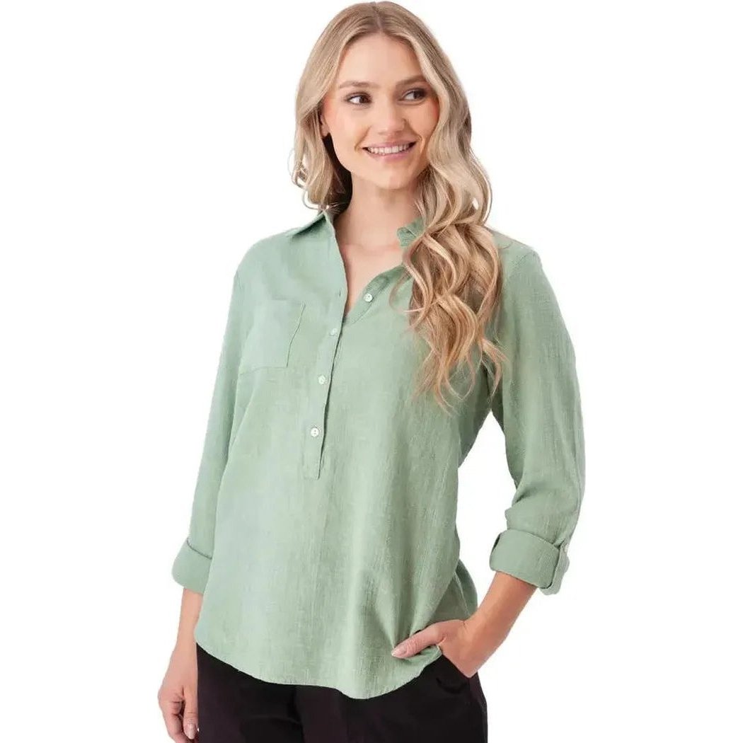 A woman wearing the Aventura Women's Laken Top in Granite Green stands against a white background with rolled-up sleeves.