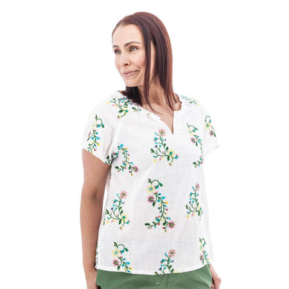 A woman wearing the Aventura Women's Lorena Top in white with floral embroidery, shown from the side against a plain white background.