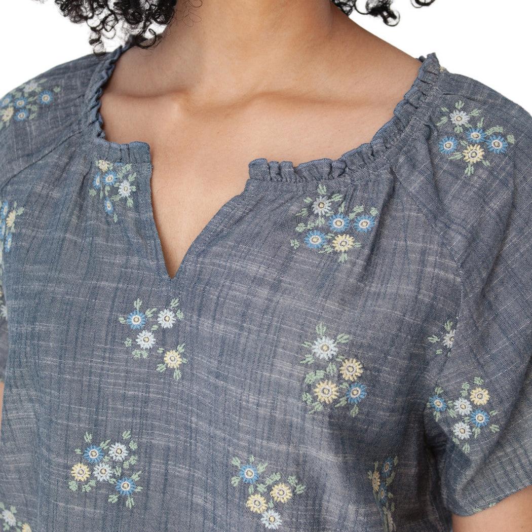 A close-up of the Aventura Women's Mariposa Top in Gibraltar Sea showing the floral pattern and V-neckline on a model.
