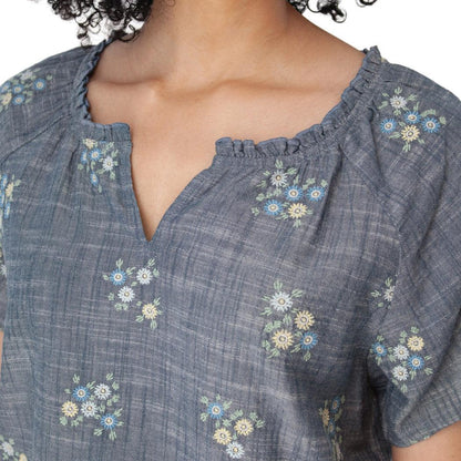 A close-up of the Aventura Women's Mariposa Top in Gibraltar Sea showing the floral pattern and V-neckline on a model.