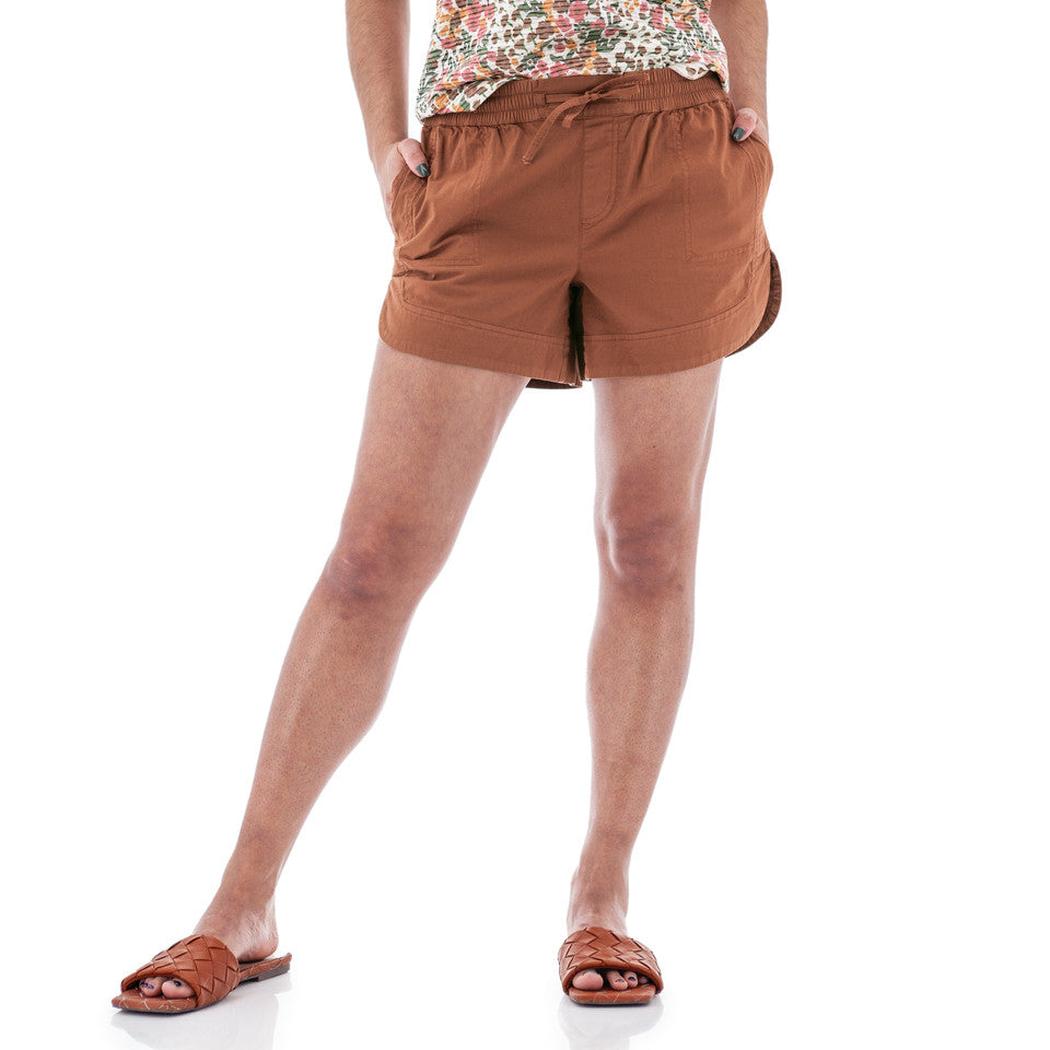 A woman wearing the Aventura Women's Parker Short in Gingerbread stands against a white background with her hands in the pockets.