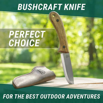 A bushcraft knife with a wooden handle and leather sheath sits on a wooden surface against a green outdoor background.