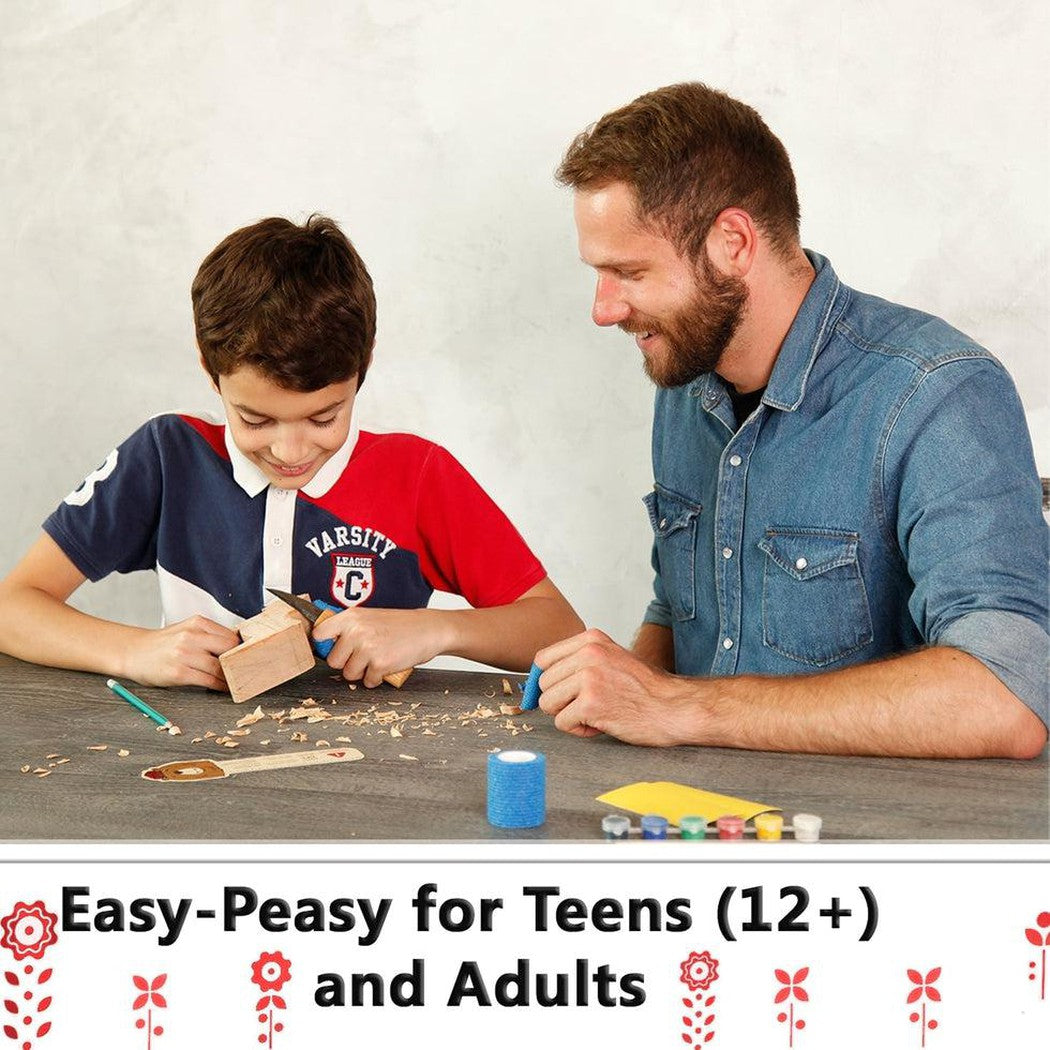 A young boy and a man work together on a Beavercraft Dala Horse Carving Kit at a table with wood shavings and tools.