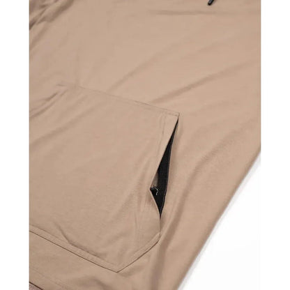 A close-up of the Belong Designs Men's Core Traverse Tek Hoodie in Dust showing the front pocket and zipper detail.