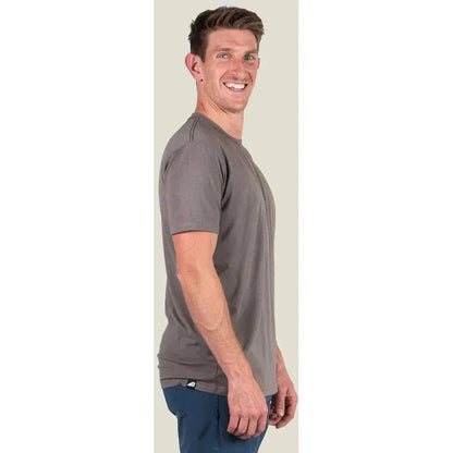 Side view of the Belong Designs Men's Core Traverse Tek Tee in Granite showing the model wearing it against a light background.