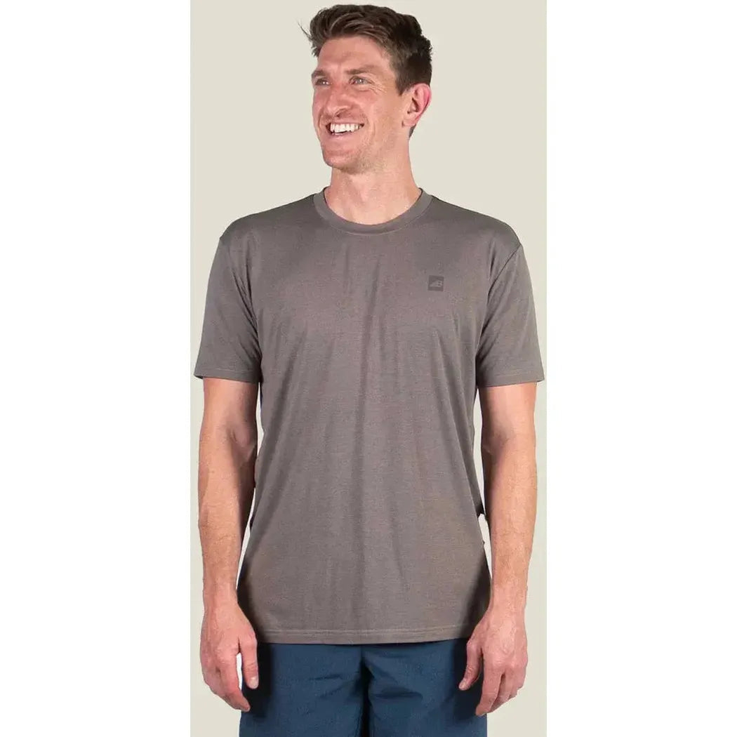 A front view of the Belong Designs Men's Core Traverse Tek Tee in Granite on a model against a light background.