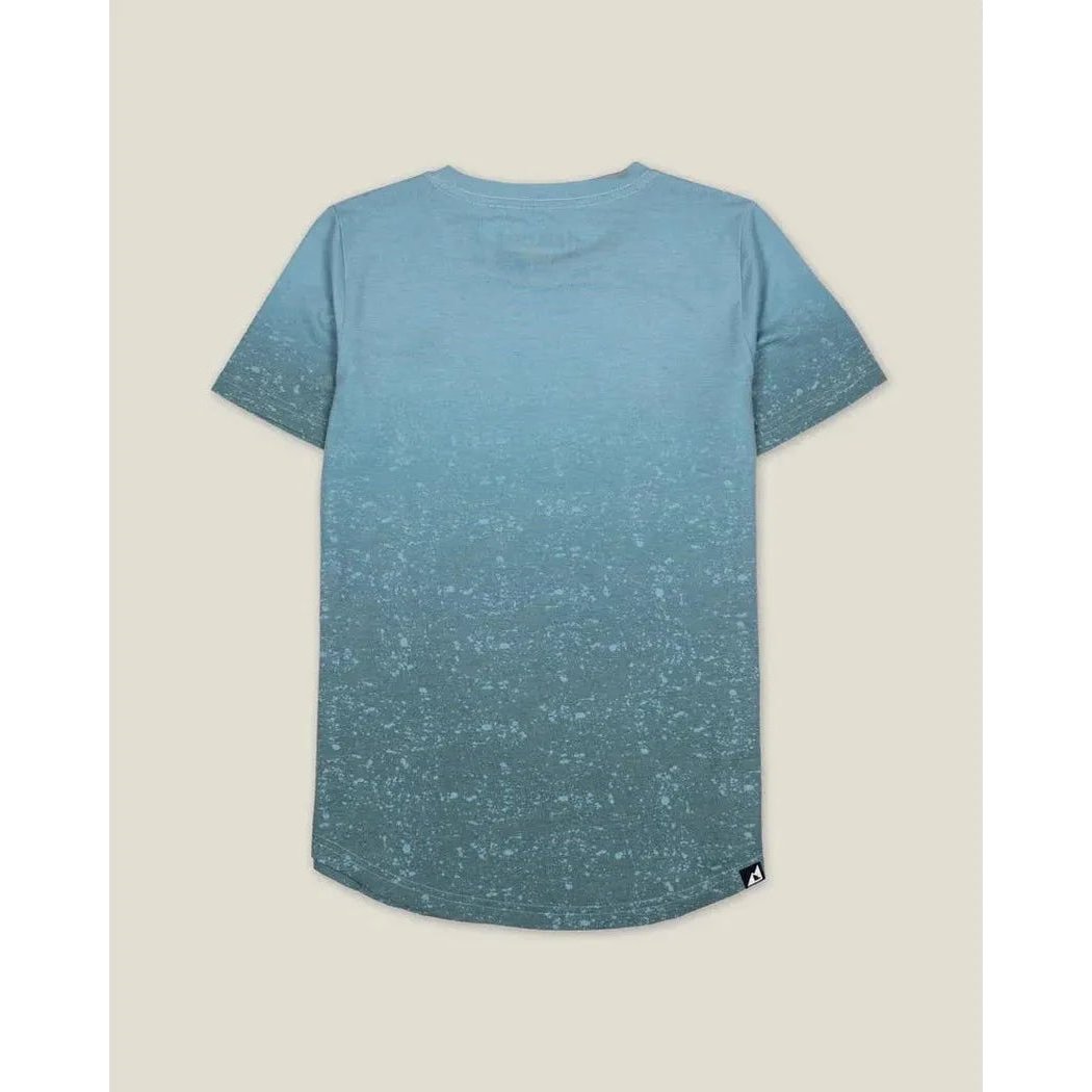 Back view of the Belong Designs Women's Graphic Traverse Tek Tee in Loam Blue with a speckled pattern against a neutral background.