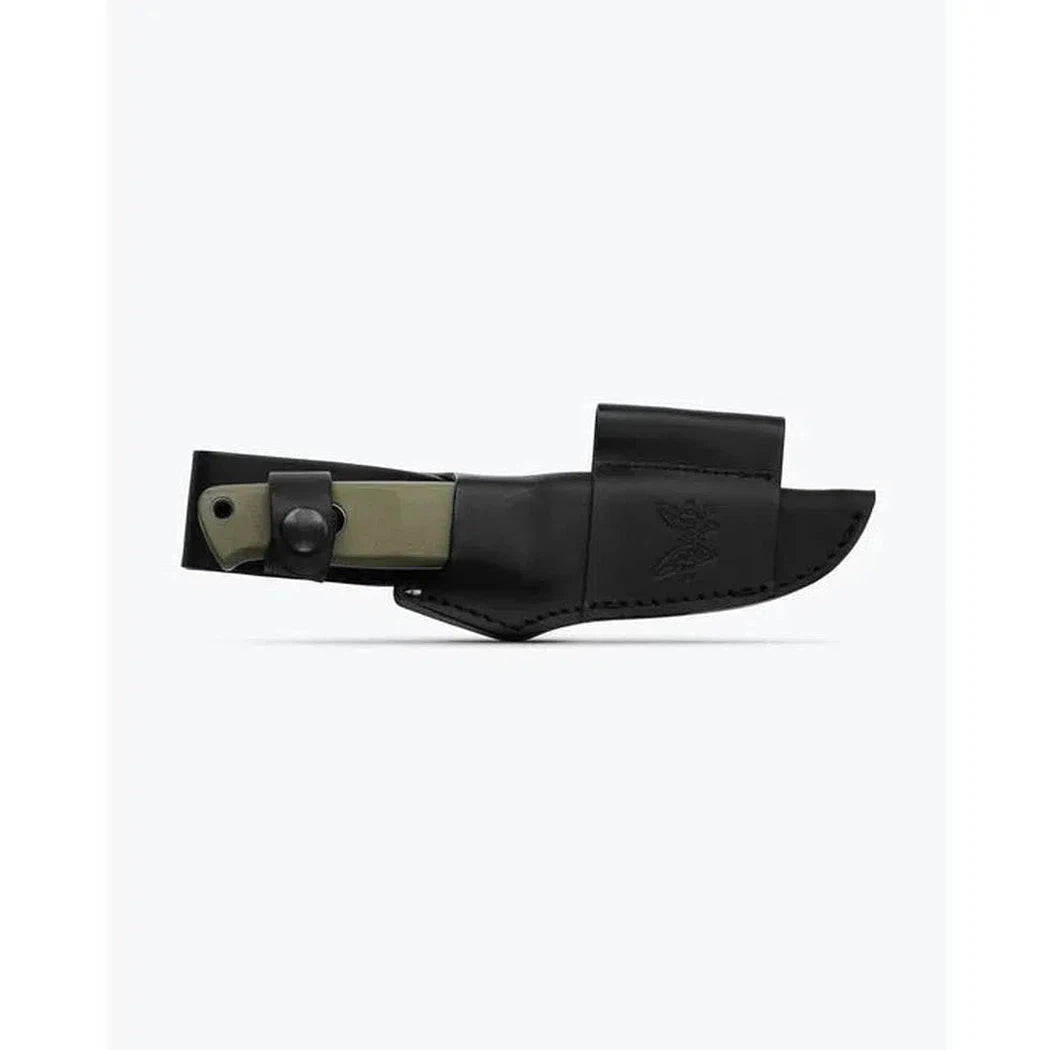 A side view of the Benchmade Mini Bushcrafter | OD Green G10 knife in its black leather sheath against a white background.