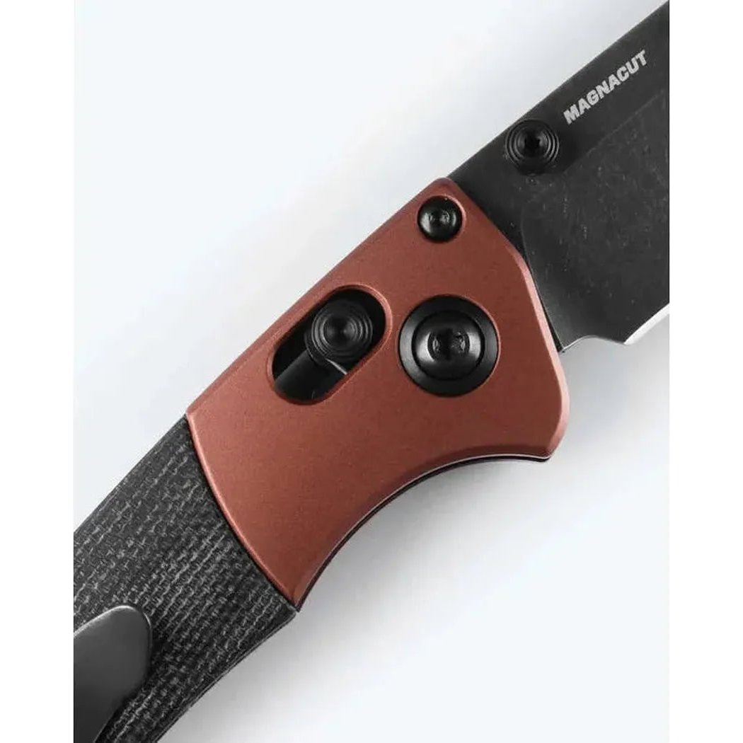 A close-up of the Benchmade Mini Crooked River knife showing its copper-colored handle and black blade against a white background.