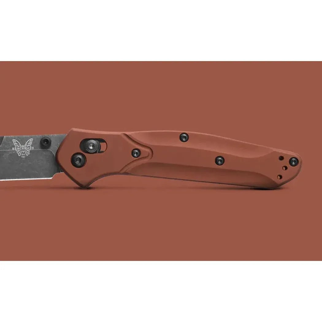 A side view of the Benchmade Osborne knife with a brown handle and black hardware against a solid brown background.