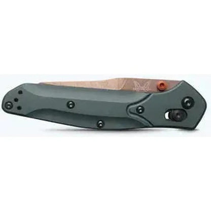 Side view of the Benchmade Osborne knife with a charcoal/gray handle and a brown blade, showing the lock mechanism and a white background.