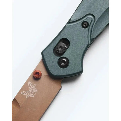 A close-up of the Benchmade Osborne knife with a charcoal/gray handle and a brown blade, showing the butterfly logo and a white background.