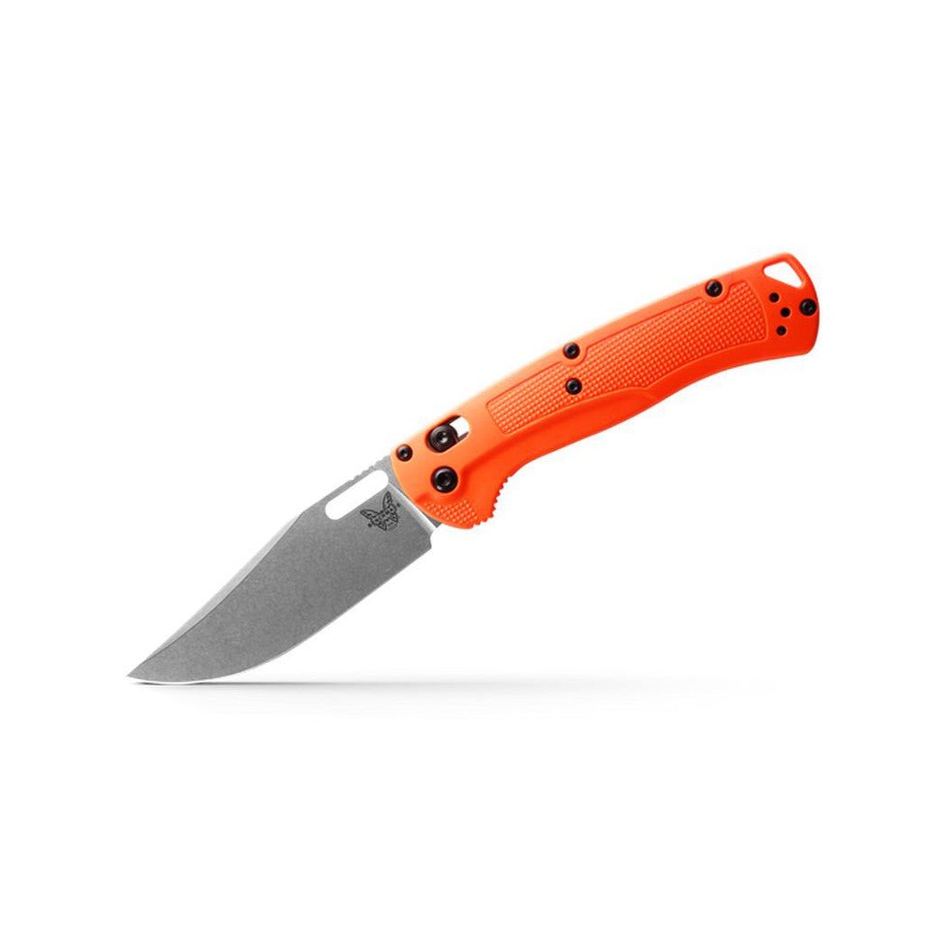 A side view of the orange Benchmade Taggedout knife with a textured handle and a white background.