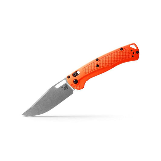 A side view of the orange Benchmade Taggedout knife with a textured handle and a white background.