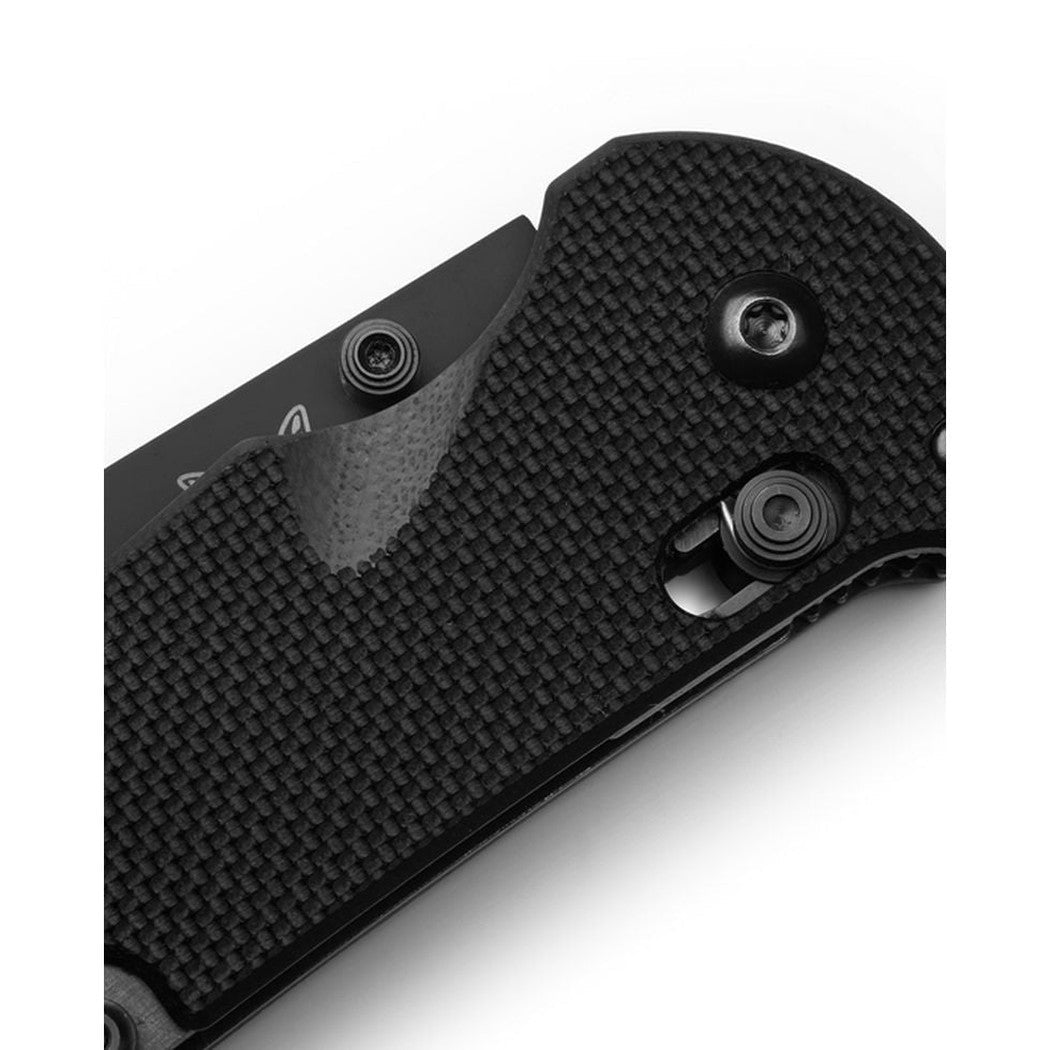 Close-up of the Benchmade Triage Family knife with textured black handle and visible pivot screws against a white background.