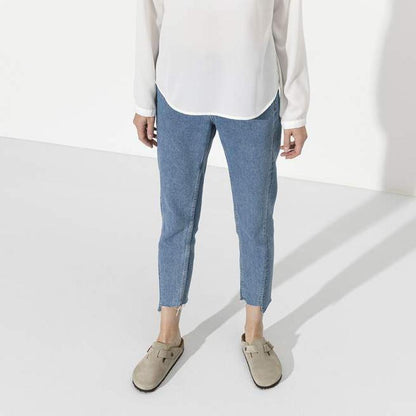 A front view of the Birkenstock Boston Soft Footbed - Suede Leather in Taupe on a model wearing cropped jeans against a white background.