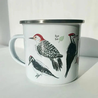 A white Brush & Bark Camping Mug with a silver rim displays three bird illustrations against a white background.