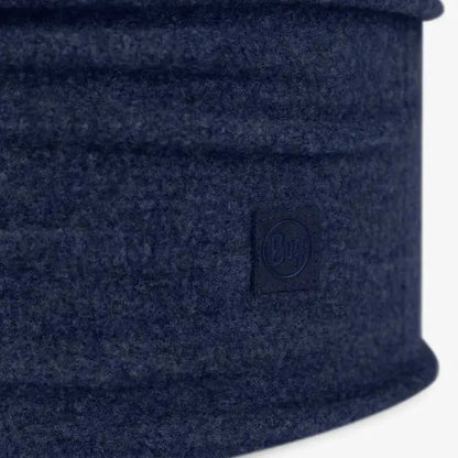 Side view of the Buff Merino Fleece - Solid Forest Green bandana showing the brand tag against a white background.