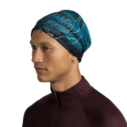 Side view of the Buff Original Ecostretch - Bryn in Tourmaline on a model wearing a maroon zip-up top against a white background.