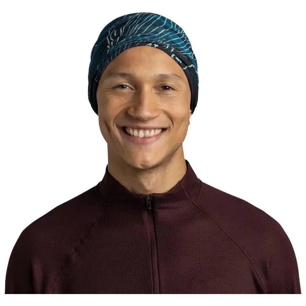 A front view of the Buff Original Ecostretch - Bryn in Tourmaline on a model wearing a maroon zip-up top against a white background.