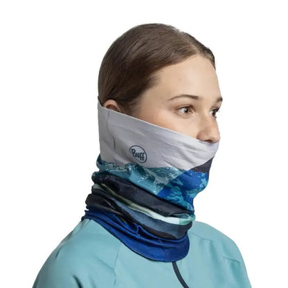 Side view of the Buff Thermonet - Munke in Blue on a model wearing a light blue top against a white background.