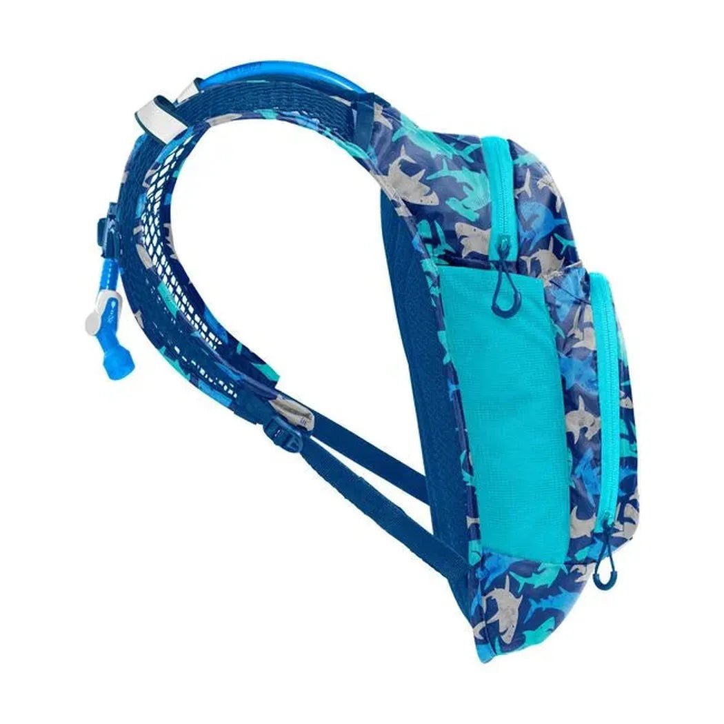 Side view of the CamelBak Mini Mule in Green/Mountains showing the hydration tube and mesh shoulder straps against a white background.