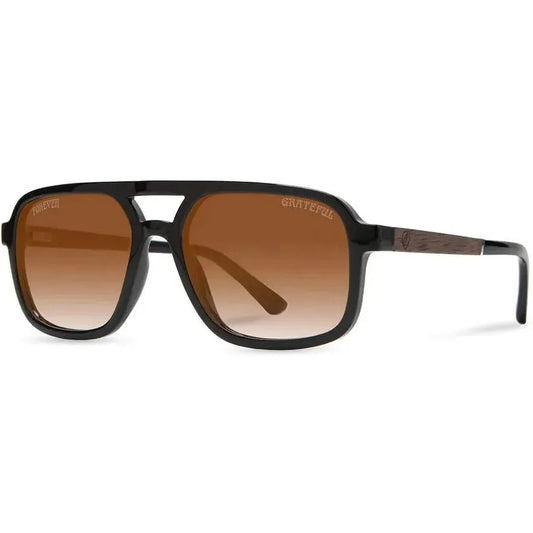 Side view of the Camp Eyewear Glacier: Grateful Dead Stealie Edition sunglasses with black frames and brown gradient lenses against a white background.