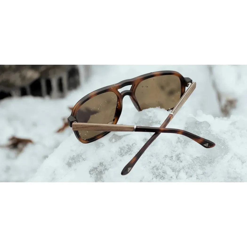 Side view of the Camp Eyewear Glacier sunglasses with tortoiseshell frames resting on snow.