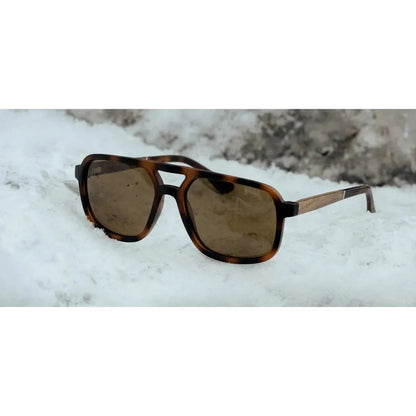 A front view of the Camp Eyewear Glacier sunglasses with tortoiseshell frames and brown lenses resting on snow.