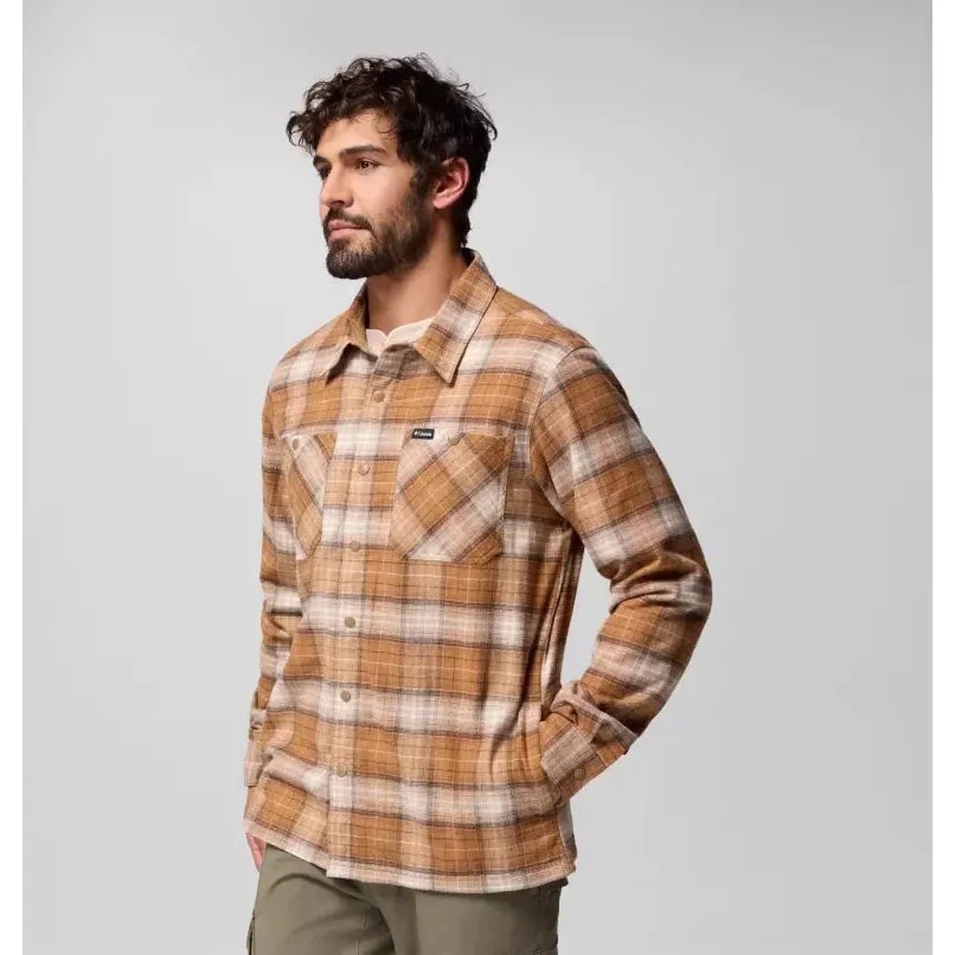 A man in a side view wears the Columbia Sportswear Men's Cornell Woods Fleece Lined Shirt Jacket in Delta Lumberjack Tartan against a plain background.