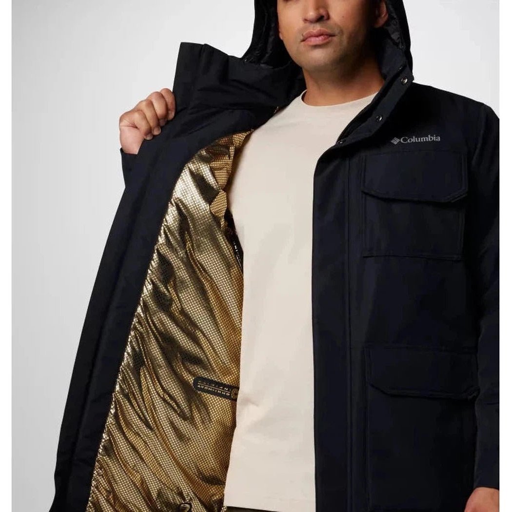 A man wearing the Columbia Sportswear Men's Landroamer II Parka in Black opens the front to show the gold-lined interior against a plain white background.